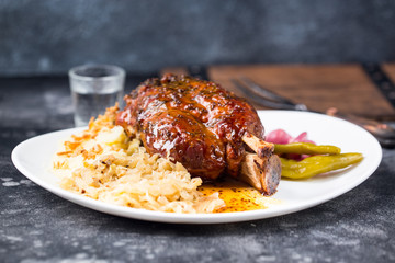 Grilled lamb leg on white plate dark background vodka