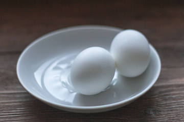 two eggs on a white saucer close-up