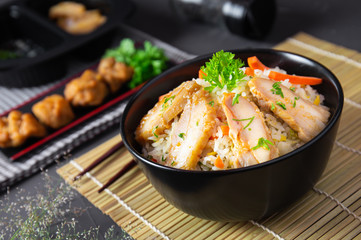 Fried rice with korean style chicken on black table