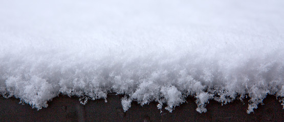 Fresh fluffy snow background. Macro shot on white snow.