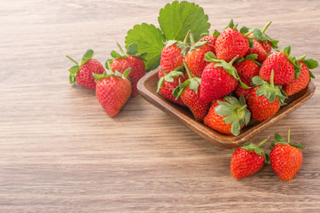 A plate of beautiful strawberries isolated on wooden background, close up, macro.