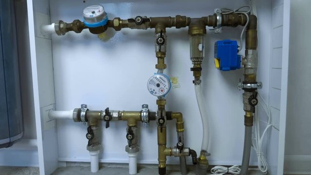 White box with a water distribution system in a residential building with pipes, taps, water meters, a mechanical filter and a water shut-off system for leaks in the boiler room. Shot in motion