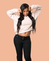 Young afro american woman showing thumb down with both hands on isolated brown background