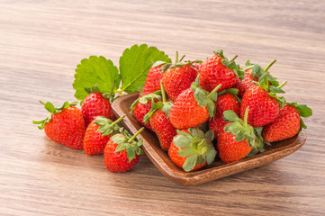 A plate of beautiful strawberries isolated on wooden background, close up, macro.