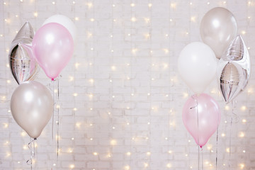 air balloons over white brick wall background with lights