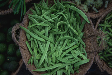 fresh, raw green beans in the market in a basket