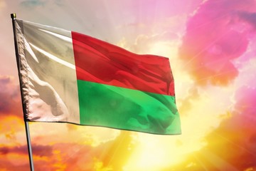 Fluttering Madagascar flag on beautiful colorful sunset or sunrise background. Success concept.