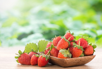 A plate of beautiful strawberries isolated on wooden background, close up, macro.
