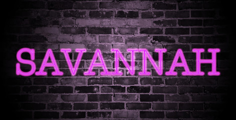 first name Savannah in pink neon on brick wall
