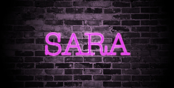 first name Sara in pink neon on brick wall