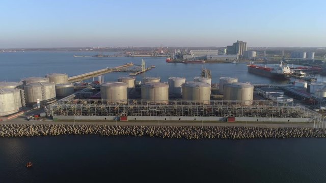 Large storage tanks of crude oil, gasoline, petrol, gas and other petrochemical goods in port terminal aerial view.