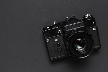 Old retro vintage camera on black background top view flat lay with copy space. Concept for the...