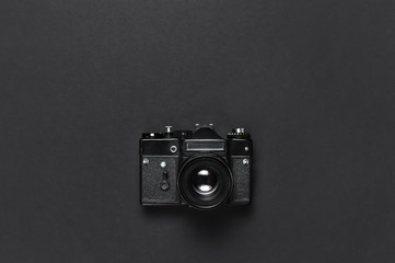 Old retro vintage camera on black background top view flat lay with copy space. Concept for the...