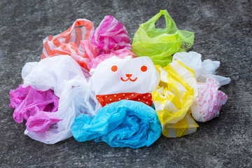 Colorful plastic bags on dark cement floor