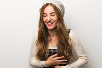 Fashionably woman wearing hat smiling a lot while putting hands on chest