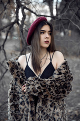 Young woman wearing fur coat and beret outdoors