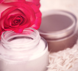 Obraz na płótnie Canvas open round jar with cream and rose