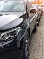 Focusing on the black car headlights on a street.