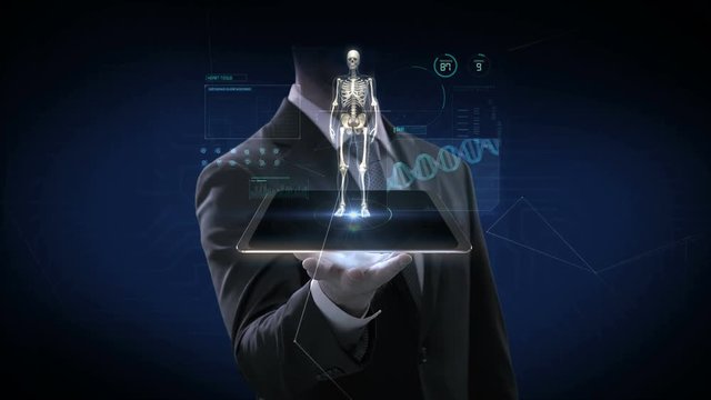 Businessman lifting smart pad, tablet, Rotating Human skeletal structure with UI,  Scanning bone system, Future medical technology. 4k animation.