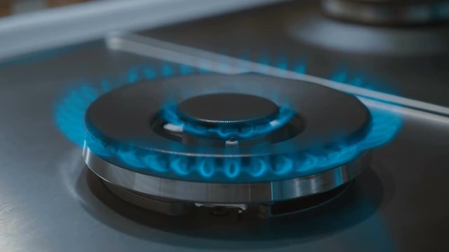 Gas igniting on the stove in the kitchen. Quick heat plate. Burner with double crown of burning gas