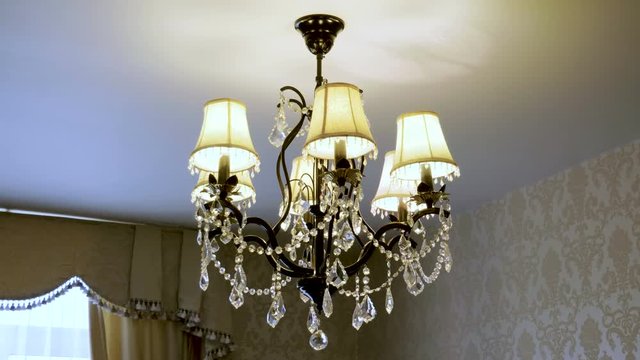 Crystal lamp. Vintage elegant chandelier hanging on the ceiling in a luxury living room. 4K