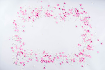 Valentine's sweets background, white background with sugar hearts sweet sprinkles, copy space top view, layout on white
