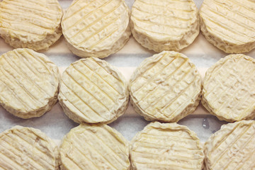 Top view on paraldon or pélardon cheese in a box. French gourmet cuisine.