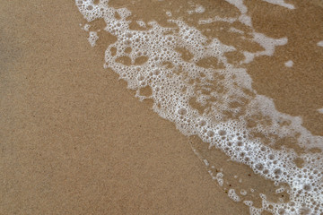 sandy sea beach with rocks and low tide in overcast day