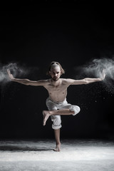 Fototapeta na wymiar Sporty young man practicing yoga, doing balance exercise on leg, balancing posture