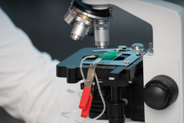 technician girl with microfluidic device LOC in microbiological lab