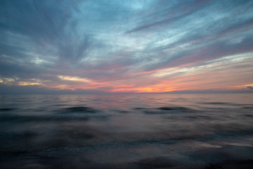 Fototapeta na wymiar dramatic high contrast clouds in sunset over seaside beach