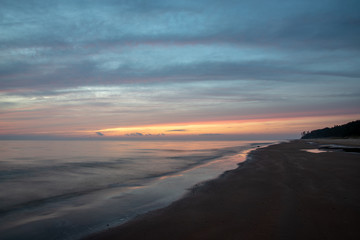 Fototapeta na wymiar dramatic high contrast clouds in sunset over seaside beach