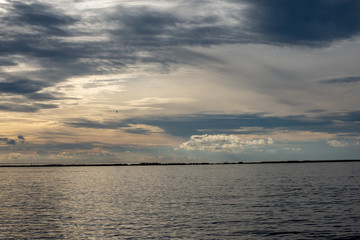 Obraz na płótnie Canvas dramatic high contrast clouds in sunset over seaside beach