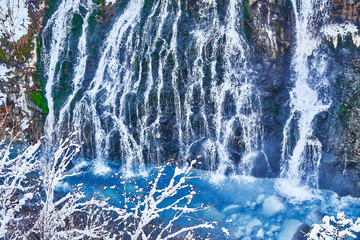 Mysterious blue, bearded waterfall and beautiful snow covering the whole world