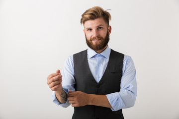 Handsome young bearded man standing isolated over white wall background posing.