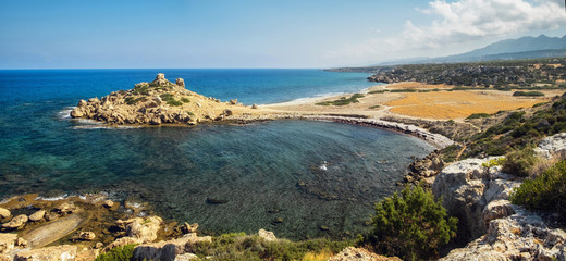 Small Alagadi beach panorama with peninsula and dry pasture