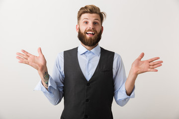 Handsome excited young bearded man standing isolated over white wall background.