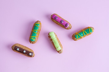 Sweet dessert French eclairs - top view closeup on pink background