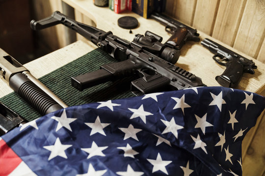 Rifles, guns and American flag on table