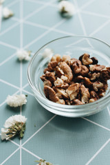 Pile of shelled walnuts in glass bowl, healthy eating concept