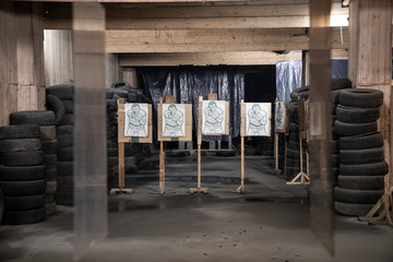 Boards with male likeness as targets in an indoor shooting range
