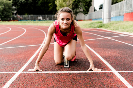 Teenage runner in starting position on race track