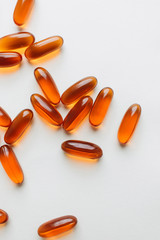 Pile of scattered capsules with medication on white background