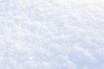 White blue snow texture background with bokeh. Close up of fresh clean snow with blue shadows. Selective focus