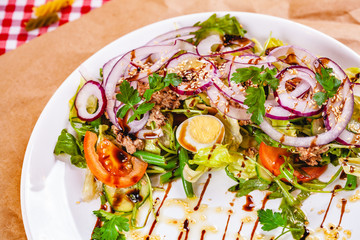 Salad with meat, egg, vegetables on white plate. Close up