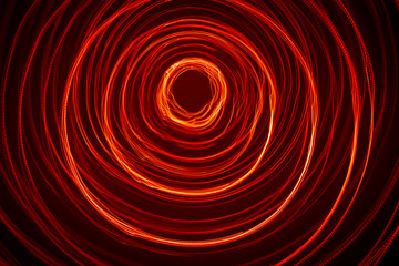 A beautiful, bright light swirl of red color. Futuristic light painting on a black background....