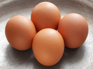 brown eggs on the background of a metal pan.
