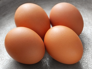 brown eggs on the background of a metal pan.