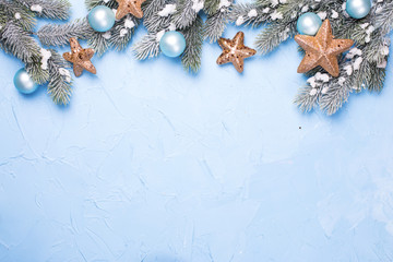 Decorative branches fir tree, golden stars and blue balls  on blue textured  background.