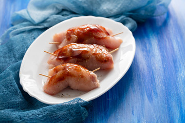 raw chicken breast with sauce on white dish